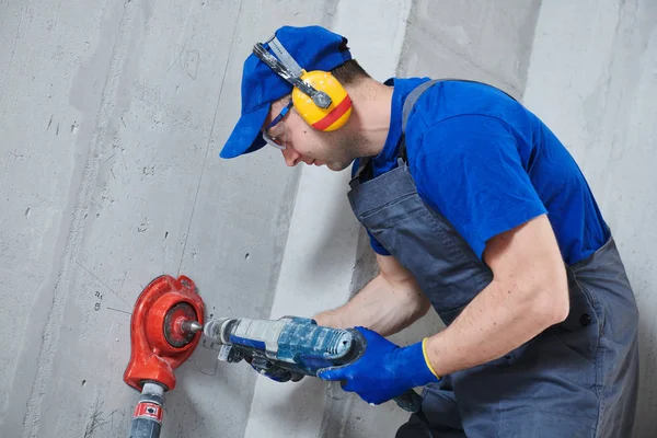 Electrician at work. boring hole for electric outlet by power tool drill. — Stock Photo, Image