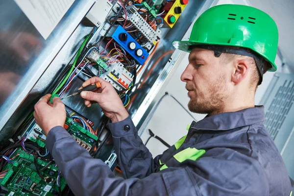 Elettricista fare manutenzione nella sala macchine di ascensore — Foto Stock