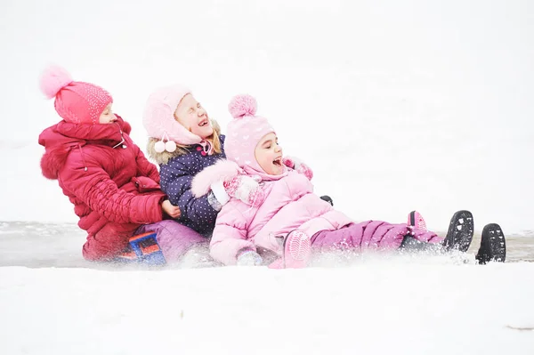 Kinderen plezier paardrijden ijs dia in de winter — Stockfoto