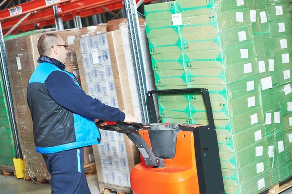 Trabajador con cajas de cartón de carga de transpaletas — Foto de Stock