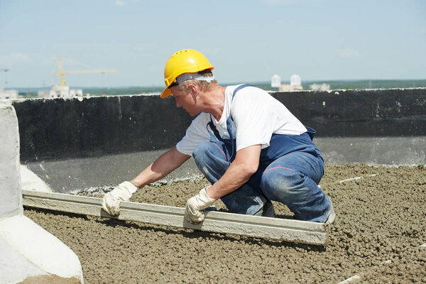 Roof construction. worker roofer leveling with float lute