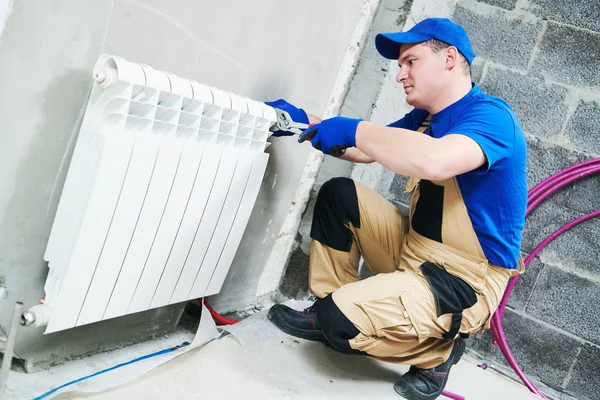 Plumber at work. Installing water heating radiator — Stock Photo, Image