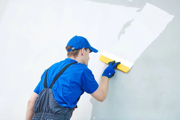Rénovation. Travailleur plâtrier écartelant un mur avec du mastic — Photo