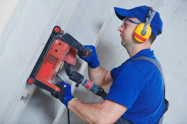 Electricista en el trabajo. corte de pared de hormigón para cableado por máquina cortadora de diamantes — Foto de Stock