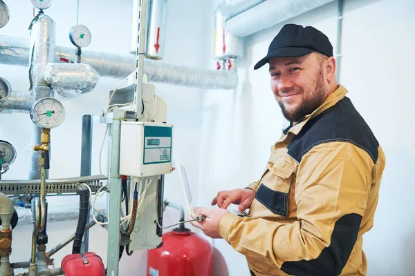 Verwarmingstechnicus of loodgieter inspecteur in ketelruimte het nemen van uitlezingen of het aanpassen meter — Stockfoto