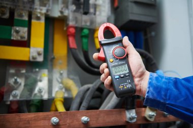 Elektrikçi iş kavramı. El ile anahtar kutusu içinde multimetre test cihazı