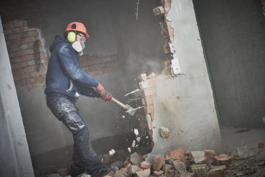 demolition work and rearrangement. worker with sledgehammer destroying wall clipart