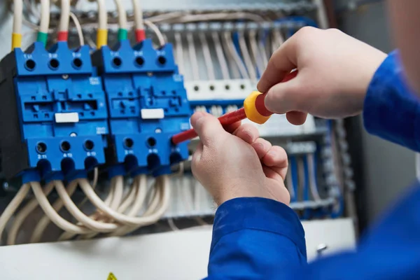 Eletricista trabalha com caixa de interruptor — Fotografia de Stock