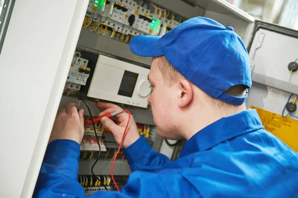 Electrician works with tester in switchbox — Stock Photo, Image