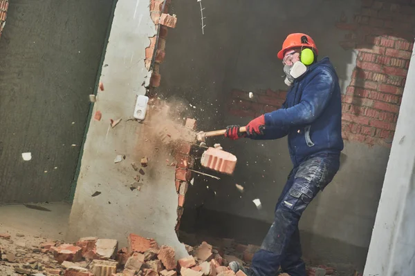 Trabalho de demolição e rearranjo. trabalhador com marreta destruindo parede — Fotografia de Stock