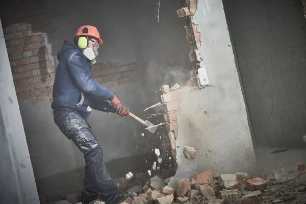 Trabalho de demolição e rearranjo. trabalhador com marreta destruindo parede — Fotografia de Stock