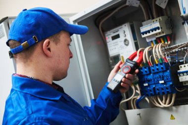 Elektrikçi iş kavramı. El ile anahtar kutusu içinde multimetre test cihazı