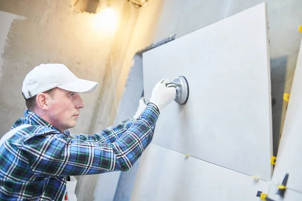 Fliesenleger installiert großformatige Fliesen an der Wand. Innensanierung zu Hause — Stockfoto