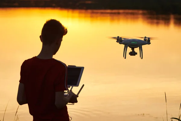 Um drone a voar. pilotagem de helicóptero ao pôr do sol do rio — Fotografia de Stock