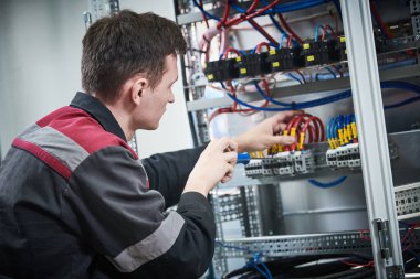 Elektrikçi, anahtar kutusunda ki anahtarlayıcılarla çalışır. akım kesici yükleme