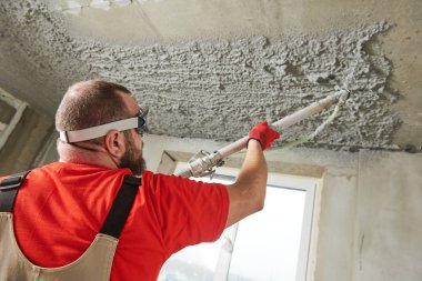 Tavanda sıva harcı koyarak püskürtme makinesi kullanarak sıvacı