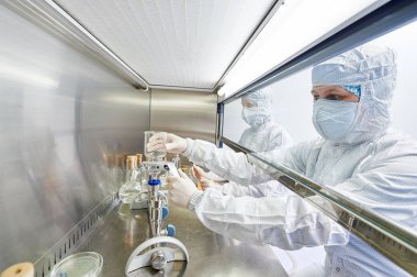 laboratuvar araştırma çalışmalarında koruyucu üniformalı bilim çalışanları