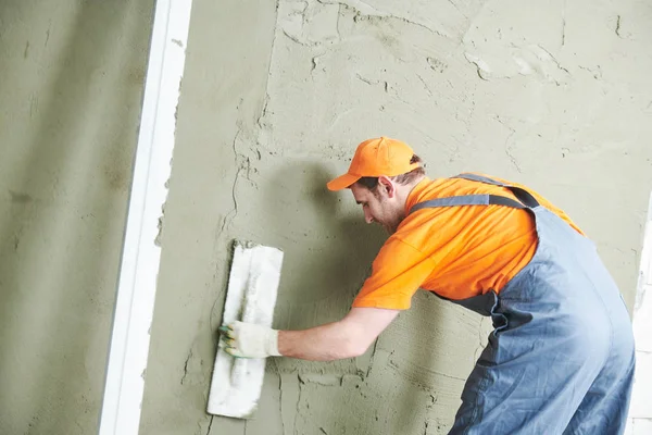 Renovatie thuis. stukadoor het gladstrijken van gips op muur. — Stockfoto