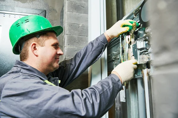 Lift machinist repairing elevator in lift shaft — Stock Photo, Image