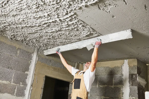 Plâtrier lissant mortier de plâtre au plafond avec chape — Photo