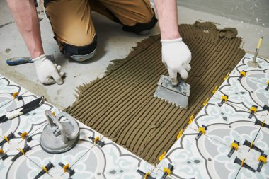 Tiler installing tile on bathroom floor. home indoors renovation clipart