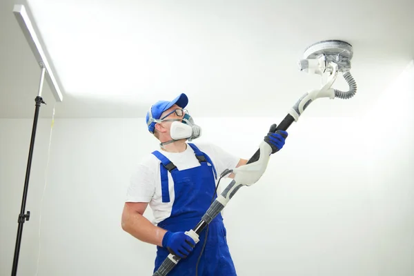 Trabajo de pintor con techo. pulido y lijado de la superficie después de masilla para pintar —  Fotos de Stock