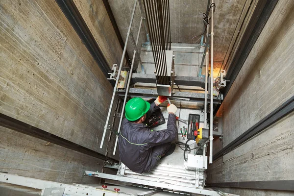 Lift machinist repairing elevator in lift shaft — Stock Photo, Image