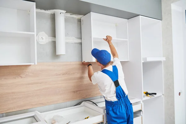 Instalación de cocina. Trabajador montando muebles — Foto de Stock