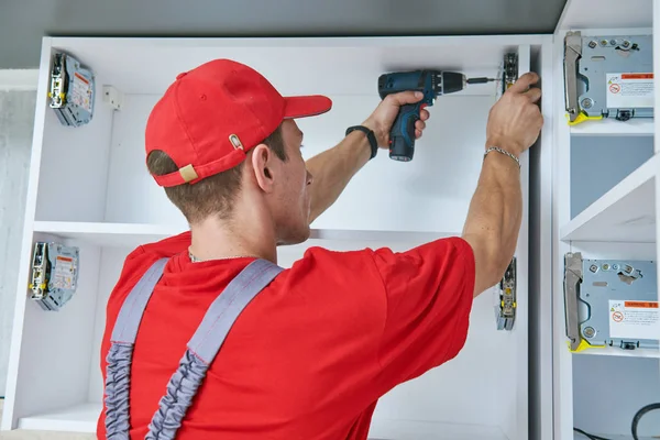 Instalación de cocina. Trabajador montando muebles — Foto de Stock