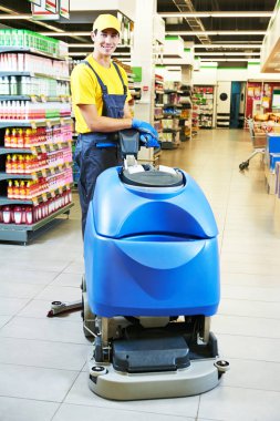 işçi mağazası zeminini makineyle temizliyor