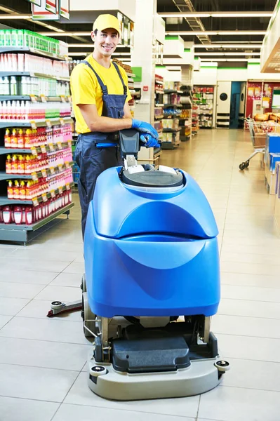 Travailleur nettoyage plancher de magasin avec machine — Photo