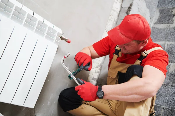 Loodgieter op het werk. Installatie van een radiator voor waterverwarming — Stockfoto