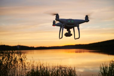 drone quadcopter günbatımında uçan dijital fotoğraf makinesi ile