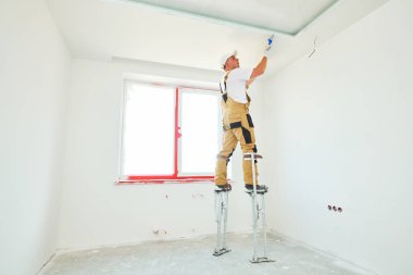 Painter in stilts with putty knife. Plasterer smoothing ceiling surface at home renewal clipart