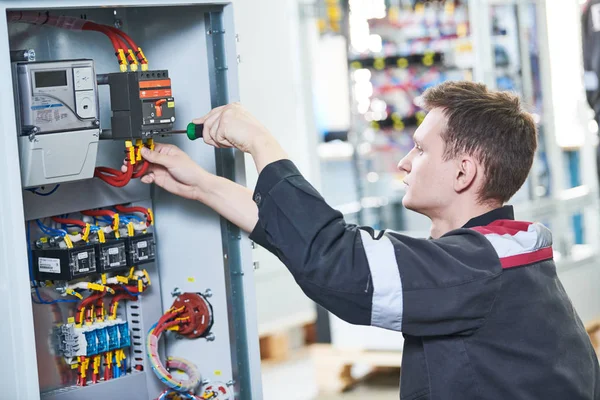 Elektricien werkt met tangen in switchbox. installatie van huidige onderbreker — Stockfoto