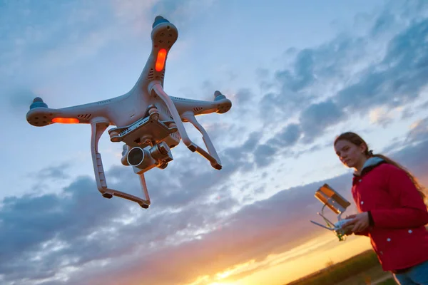 Drone repül naplementekor pilóta a fiatal nő — Stock Fotó