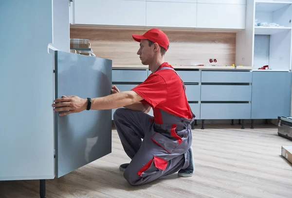 Instalación de cocina. Trabajador montando muebles — Foto de Stock