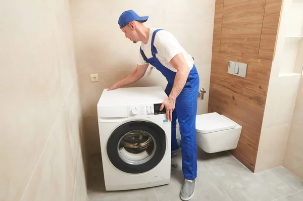 Washing machine installation. plumber placing appliance for service — Stock Photo, Image