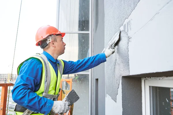 Trabajador de fachada enlucido pared exterior del edificio — Foto de Stock