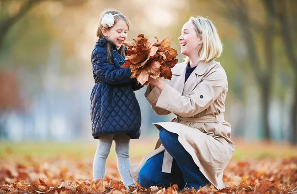 Madre jugando con un niño pequeño en el parque de otoño —  Fotos de Stock