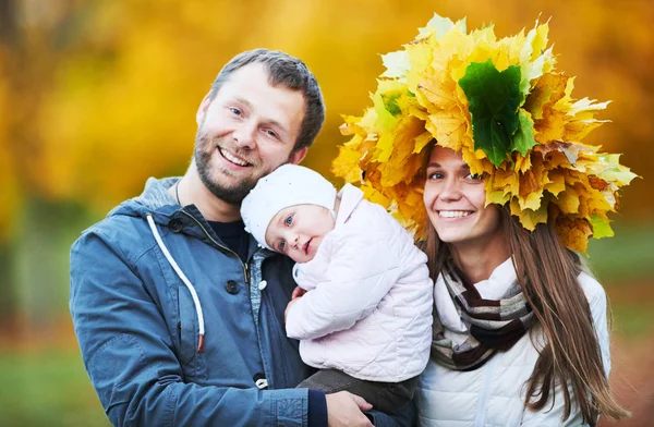 幸福的年轻家庭的画像与女婴在秋天公园 — 图库照片