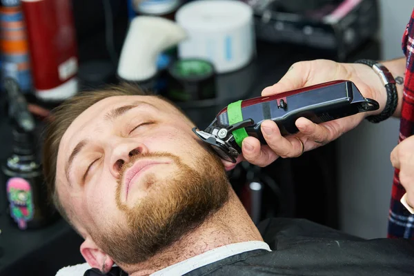 Baard verzorging. man terwijl zijn gezichtshaar te trimmen op de barbershop gesneden — Stockfoto