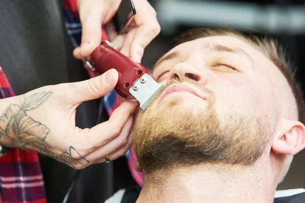 Baard verzorging. man terwijl zijn gezichtshaar te trimmen op de barbershop gesneden — Stockfoto