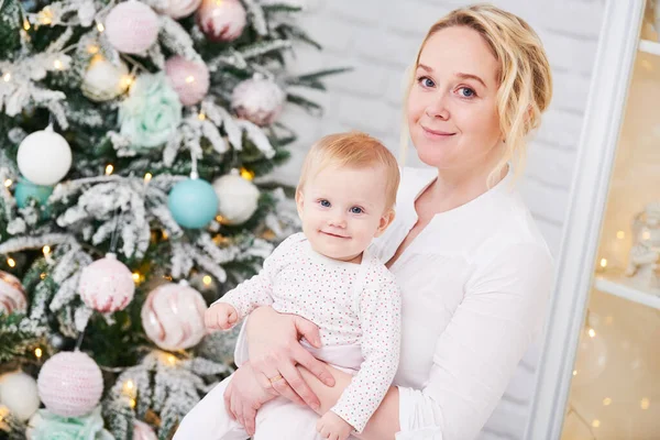 Família de pais. Mãe e bebê pequeno na frente da árvore de Natal — Fotografia de Stock