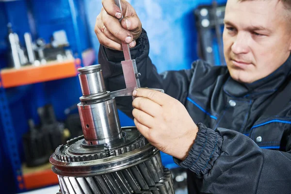 Truck repair service. serviceman measuring gear shaft of gearbox — Stock Photo, Image