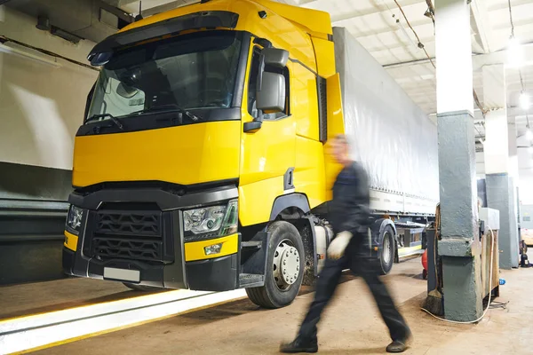 Truck repair service. Mechanic walks for tool in front of lorrytruck workshop — Stock Photo, Image