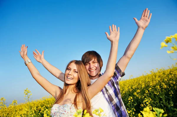Giovani adulti felici insieme nel campo estivo mani in alto — Foto Stock