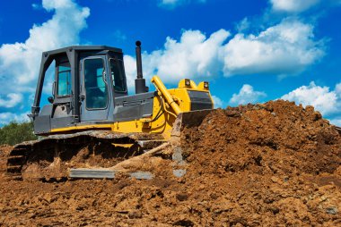 Buldozer toprağı hareket ettiriyor. Yol yapım işi