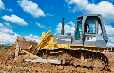 Buldozer toprağı hareket ettiriyor. Yol yapım işi