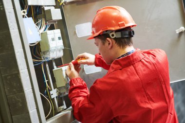 Elektrikçi enerji tasarrufu sayacını kuruyor ya da onarıyor. Bakım servisi